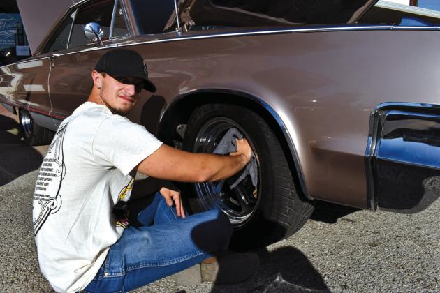 Austin Van Lew of Warsaw, Missouri, shines the rims of a 1965 Chrysler 300 courtesy photo
