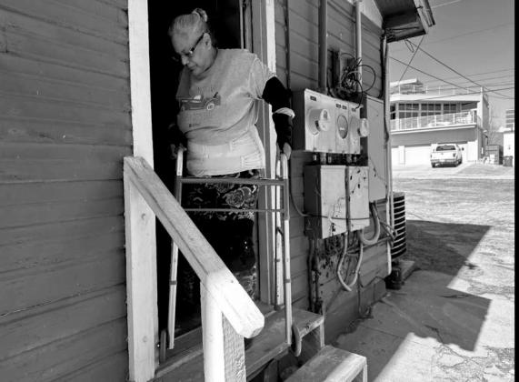 Elena Rodriguez, a disabled Oklahoma City woman, maneuvers her walker over the wooden stairs that lead to her apartment.
