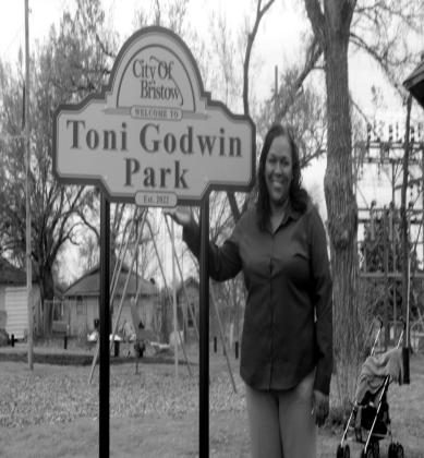 Toni Godwin, Bristow Social Services Director, stands in front of the new sign at the park located at Tenth and Chestnut. The park was recently renovated and dedicated in Godwin’s honor. Vicki Grisham photo
