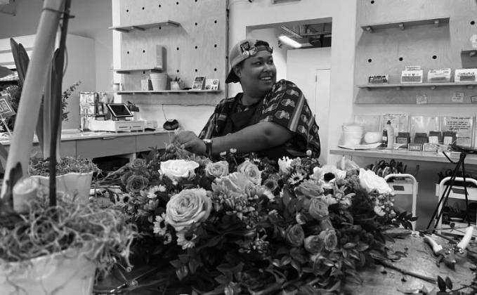 D'Metryus Freeman adds flowers to a wreath while at work at Curbside Flowers on Jan. 12. Curbside Flowers employees were preparing the arrangement for a Homeless Alliance funeral honoring 67 people that had died in 2022 while experiencing homelessness or after having been housed.