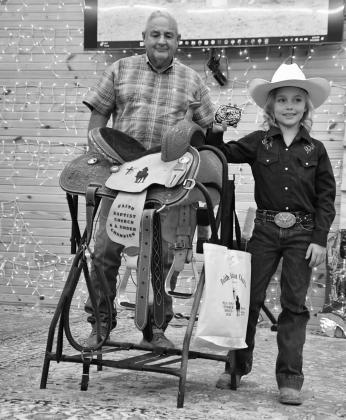 Pastor Steve Lamberson presents Rainey Sharp, from Beggs, with a saddle for the age six and under group.