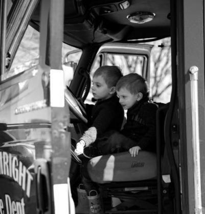 Two young boys resemble future firefighters as they explore an emergency vehicle. courtesy photo