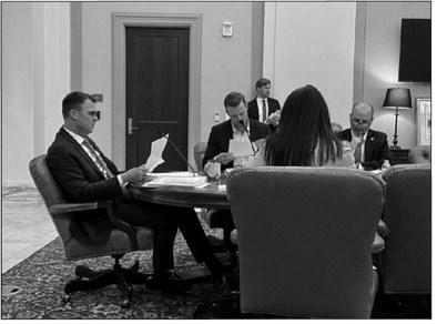 Oklahoma Gov. Kevin Stitt, left, reads meeting documents at a June 7, 2023, meeting of the Commissioners of the Land Office at the Oklahoma Capitol in Oklahoma City. Commissioners voted at the meeting to stop doing business with BlackRock and JPMorgan Chase because the financial firms were perceived as being hostile to the oil and gas industry.